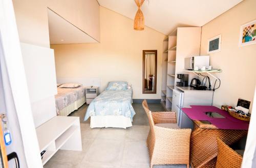 费尔南多 - 迪诺罗尼亚Horizonte Azul Noronha的小房间设有一张床、一张桌子和一间卧室