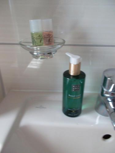诺特海姆Ferienwohnung Jürges的浴室水槽上摆放着一瓶绿色肥皂