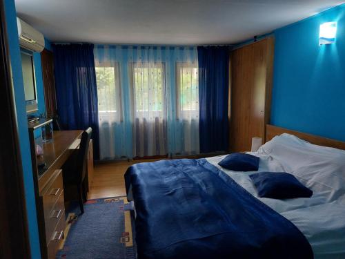 内霍瓦蒙大拿旅游酒店的一间卧室设有一张床和蓝色的墙壁