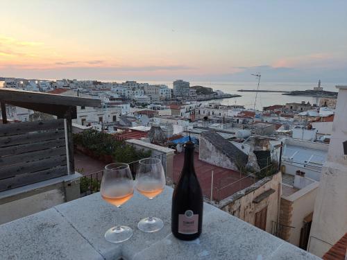 维耶斯泰Terrazza Santoro per la vostra estate da sogno!!!的一瓶葡萄酒和两杯酒杯