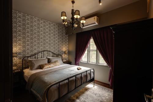 班加罗尔Hoodo Zoe - Hebbal Bangalore Apartments的一间卧室配有一张带吊灯和窗户的床。