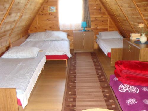 雅罗斯瓦维茨Domki u Uli的配有窗户的小木屋内的两张床
