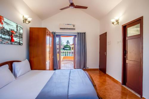 马尔冈'Golden Coral' 2bhk Benaulim Beach villa Goa的一间卧室设有一张床,并有通往阳台的门