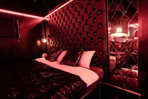 格但斯克Grey Secret Champagne Apartament Spa的红色的房间,配有一张带床头板的床