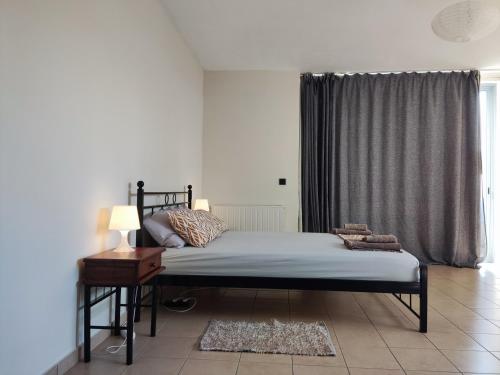 帕萨里迪Yiorgos, amazing sunset view house的一间卧室配有一张床、一张桌子和一个窗户。
