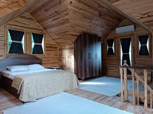 MackaDiamond Tree House的木制客房内的一间卧室,配有一张床