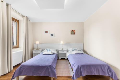 斯维特温斯纳特Villa San Vincenti的紫色床单的客房内的两张床