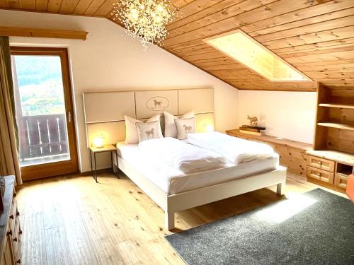 奥蒂塞伊Chalet Bernardi Apartments的卧室配有白色的床和吊灯。