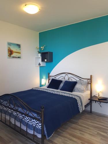 科佩尔Apartment and rooms Parus的一间卧室设有一张蓝色墙壁的大床