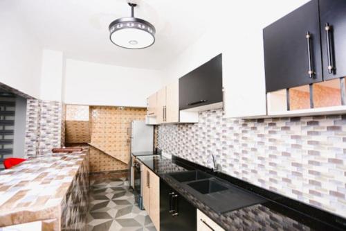 洛美Villa Flo Residence的厨房配有白色橱柜和黑色台面