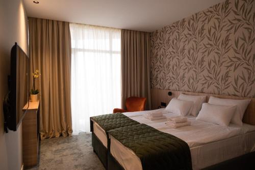 斯雷姆斯卡米特罗维察HOTEL GRACIAN的酒店客房,配有一张带绿毯的床