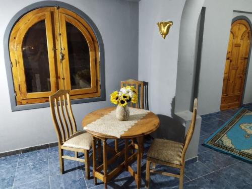 卢克索Gabawy Garden Ferienwohnung的餐桌、椅子和花瓶