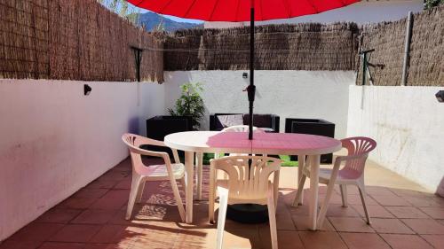 德拉塞尔瓦港Port de la Selva apartament的庭院里配有桌椅和红伞