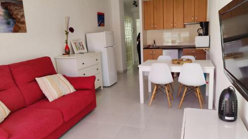 德拉塞尔瓦港Port de la Selva apartament的一间带红色沙发的客厅和一间厨房