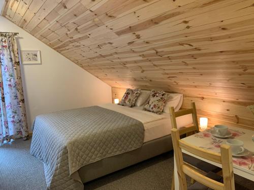 ChocieszowModrzewiowe Zacisze的一间卧室设有一张床和木制天花板