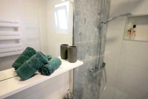赫瓦尔House La Vista Hvar的浴室设有位于架子上的绿色毛巾和淋浴。
