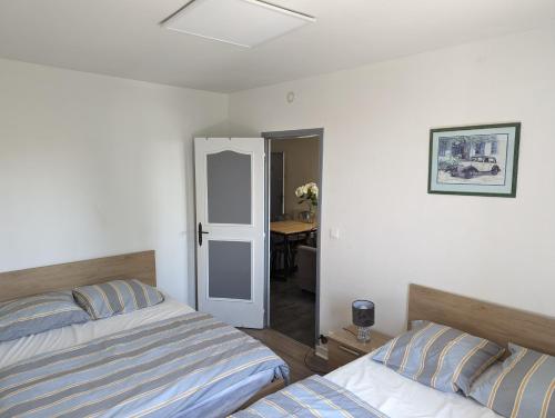 普瓦捷Appartement meublé proche du futuroscope的一间卧室配有两张床和一张桌子。