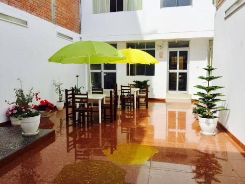 巴兰卡HOTEL CASTILLO MAGICO (EX CHAVIN SEÑORIAL?的一个带桌椅和遮阳伞的庭院。