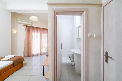 利迈纳里亚Hotel Papageorgiou的一间卧室配有一张床,浴室设有水槽