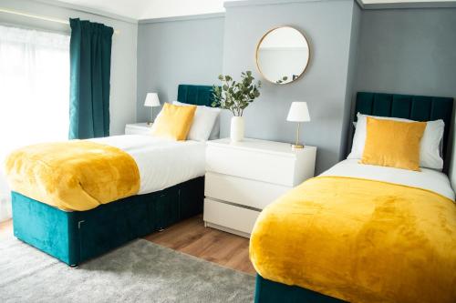 伊灵Luxury Cityscape London - Free Parking!的卧室设有两张黄色和蓝色的床