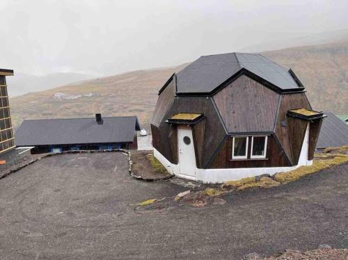 LeynarUnique dome / igloo的一座位于山上的棕色大房子,屋顶黑色