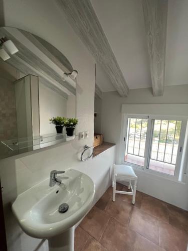 马拉加Casa rural Las Casillas的白色的浴室设有水槽和镜子
