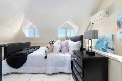金斯敦Vacay with Tiffany的一间卧室配有带白色床单和枕头的床。