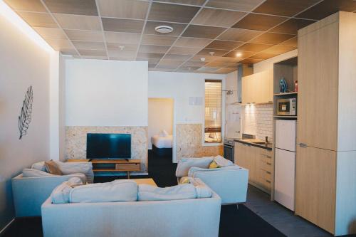 惠灵顿Liberty Apartment Hotel的客厅配有两张沙发和一台电视