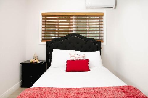 Exuma Harbour EstatesSheer Bliss BeachView Apt #2的一间卧室配有一张红色枕头的床
