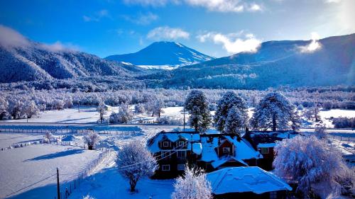 马拉卡韦罗Hostal Piedra Santa的一座雪覆盖的房子,背景是一座山