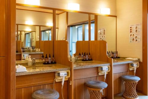 SagaeHotel Symphony Annex Sagae Onsen的浴室设有两个盥洗盆、镜子和凳子
