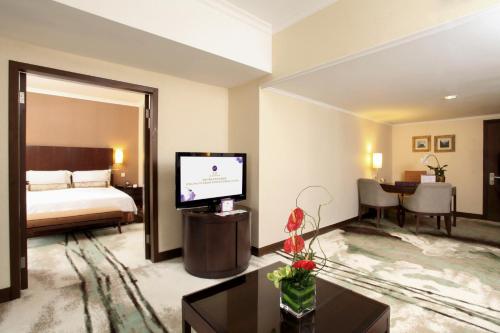 北京北京西单美爵酒店的酒店客房,配有床和电视