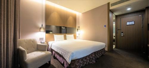 泰山丽京栈酒店的配有一张床和一把椅子的酒店客房