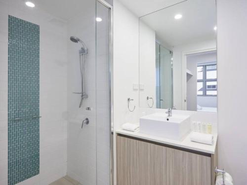 黄金海岸Two bedroom Apartment in Robina Center的白色的浴室设有水槽和淋浴。