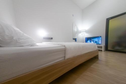 南府Paknap Hostel的卧室配有一张大床,墙上配有电视