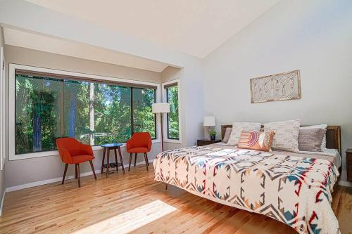贝尔维尤Sunlit contemporary Bellevue Home w a Lush Garden的卧室配有一张床和一张桌子及椅子