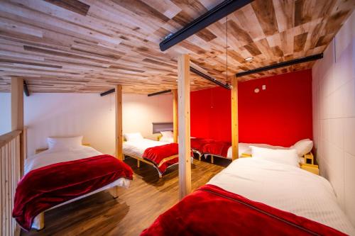 千葉地域ランキング1位獲得の贅沢な貸別荘全4棟的红色墙壁的客房内的两张床