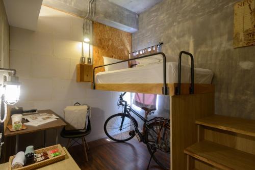 花莲市花莲洄澜窝青年旅舍的一间设有双层床的房间和一辆自行车