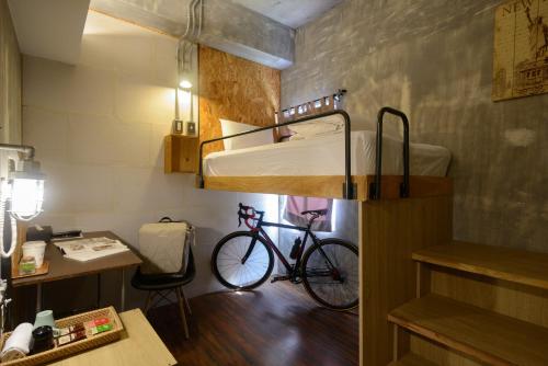 花莲市花莲洄澜窝青年旅舍的一间房间,配有一辆自行车停放在双层床上