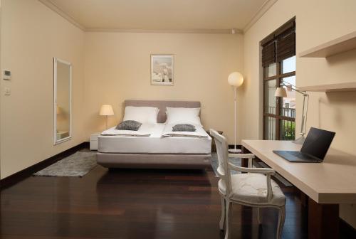 斯普利特Exclusive Villa Marnano - Split center的一间卧室配有一张床和一张带笔记本电脑的书桌