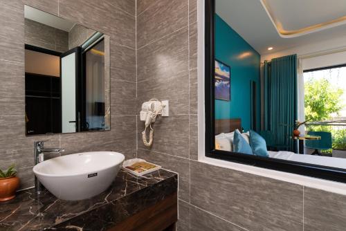 会安Hoianese Hotel - Lip Lip Pool Villa的一间带水槽和镜子的浴室