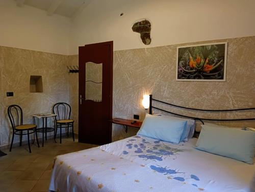 塞斯塔戈达诺Terra Del Bosco Agriturismo的卧室配有一张床和一张桌子及椅子