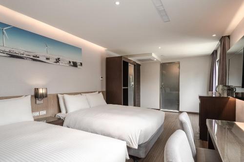 高雄佑煦行旅的酒店客房配有两张床和一张书桌