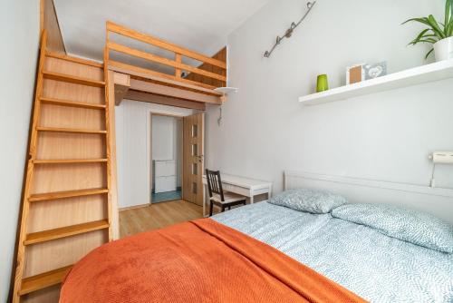 格但斯克Apartment in City Center的一间卧室配有一张带梯子的床和一张书桌