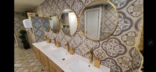 耶路撒冷CAPSULES & Dormitory BH的浴室设有3个水槽和墙上的镜子