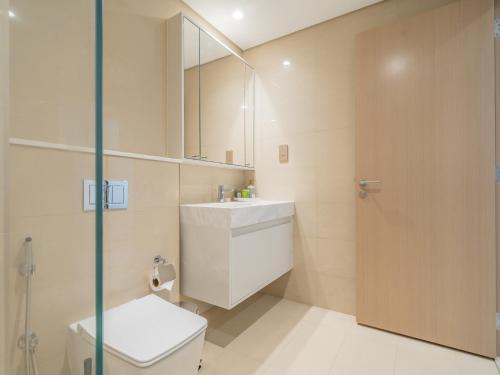 迪拜Downtown Decadence : A 1BR Urban Sanctuary的一间带卫生间、水槽和镜子的浴室