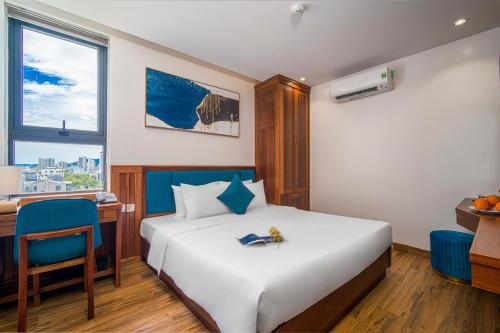 岘港Sea Wind Hotel by THG的配有一张床、一张书桌和一扇窗户的酒店客房