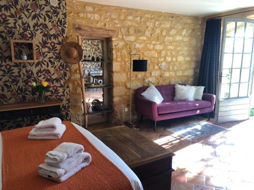 卡斯泰尔诺拉沙佩尔La Tour de Cause的一间卧室配有一张床和一张紫色沙发