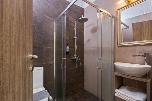 赫索尼索斯Charm Hotel, Hersonissos的一间带玻璃淋浴间和水槽的浴室