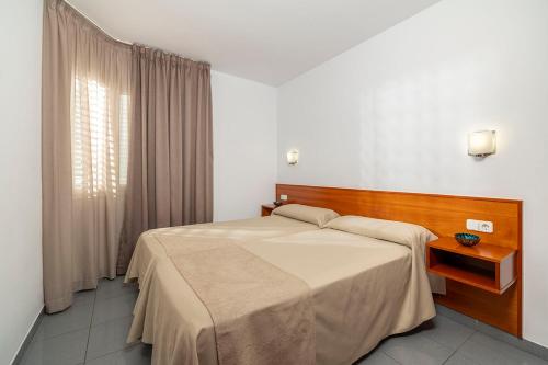 罗列特海岸布劳公寓的一间卧室设有一张大床和一个窗户。